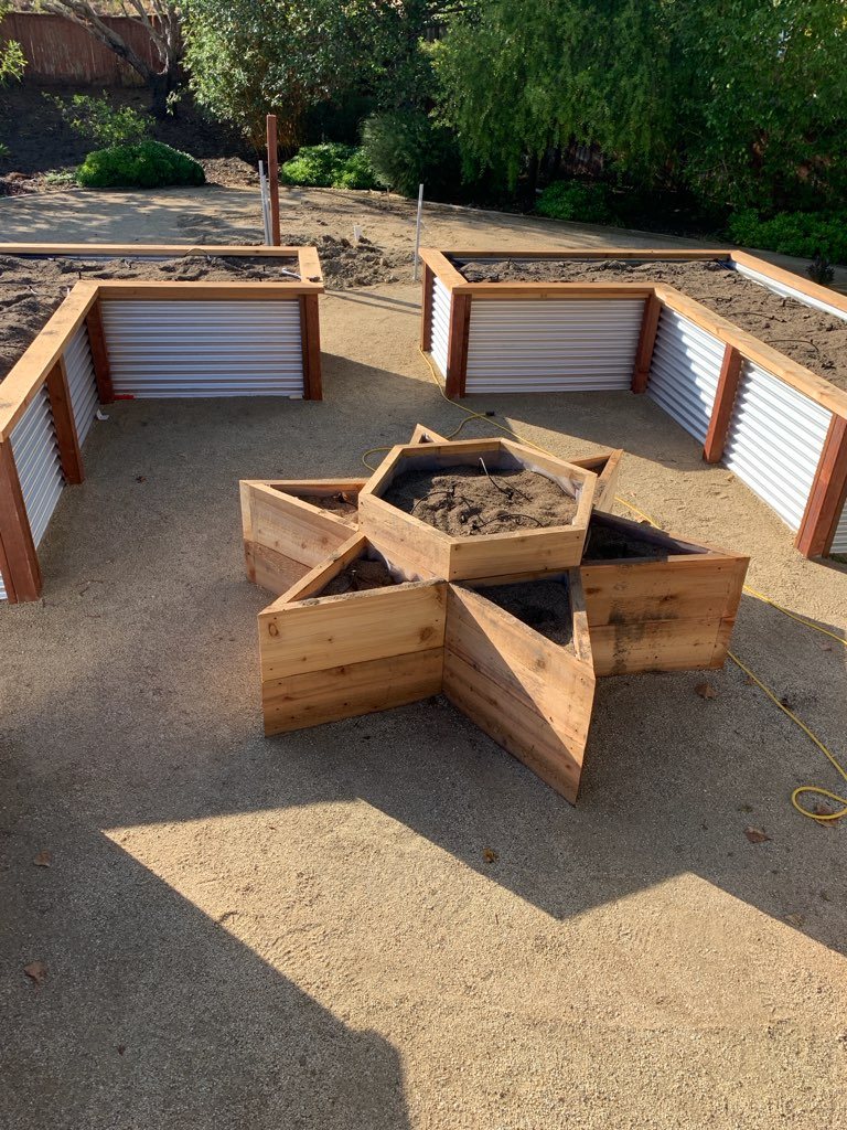 Cedar raised garden beds with corrugated metal sides and a star-shaped center planter