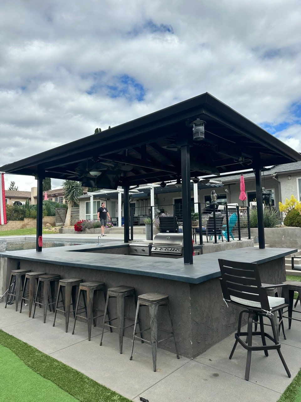 Covered outdoor bar pavilion with concrete counter and bar stools