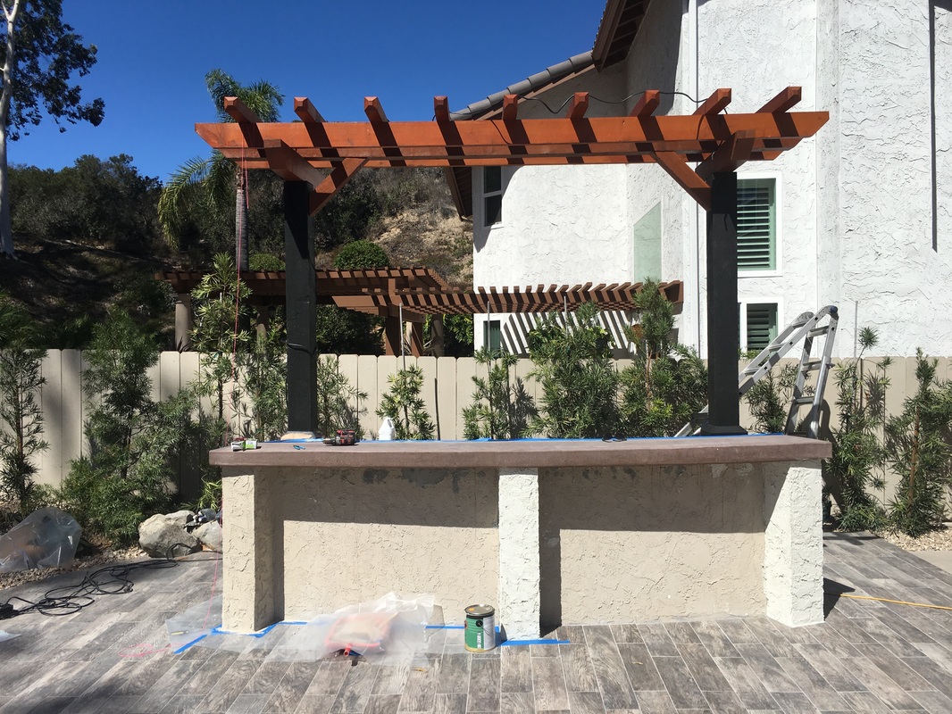 BBQ island mid-construction with stone veneer in progress