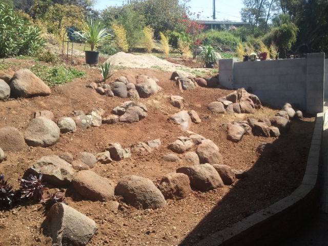 Boulder retaining feature on renovated hillside slope
